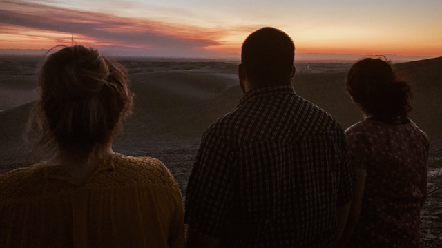 Roadtrippers Ericka, Anthony and Joccelyn ponder what they’ve learned on their journey, surrounded by sunset in Glamis, California.